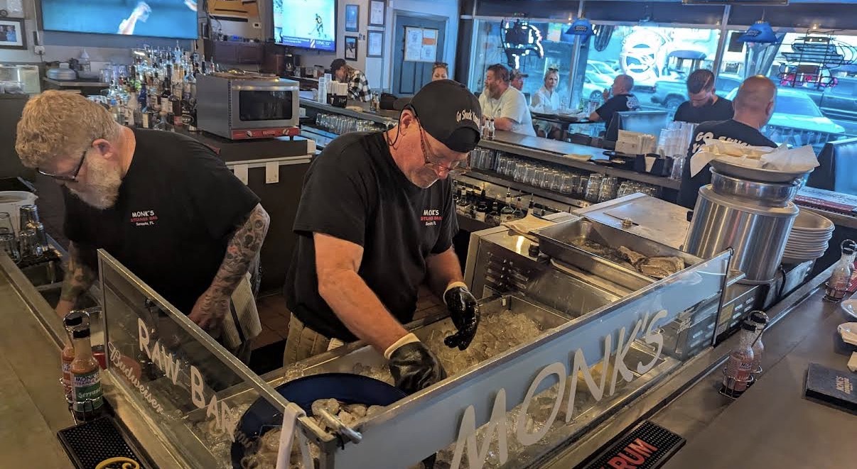 Bartenders shucking oysters at Monk's bar